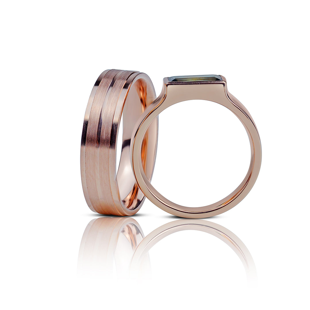 vestuviniai ziedai su turmalinu is rausvo aukso, gulejantys ant baltos bazes, svelnus minimalizmas